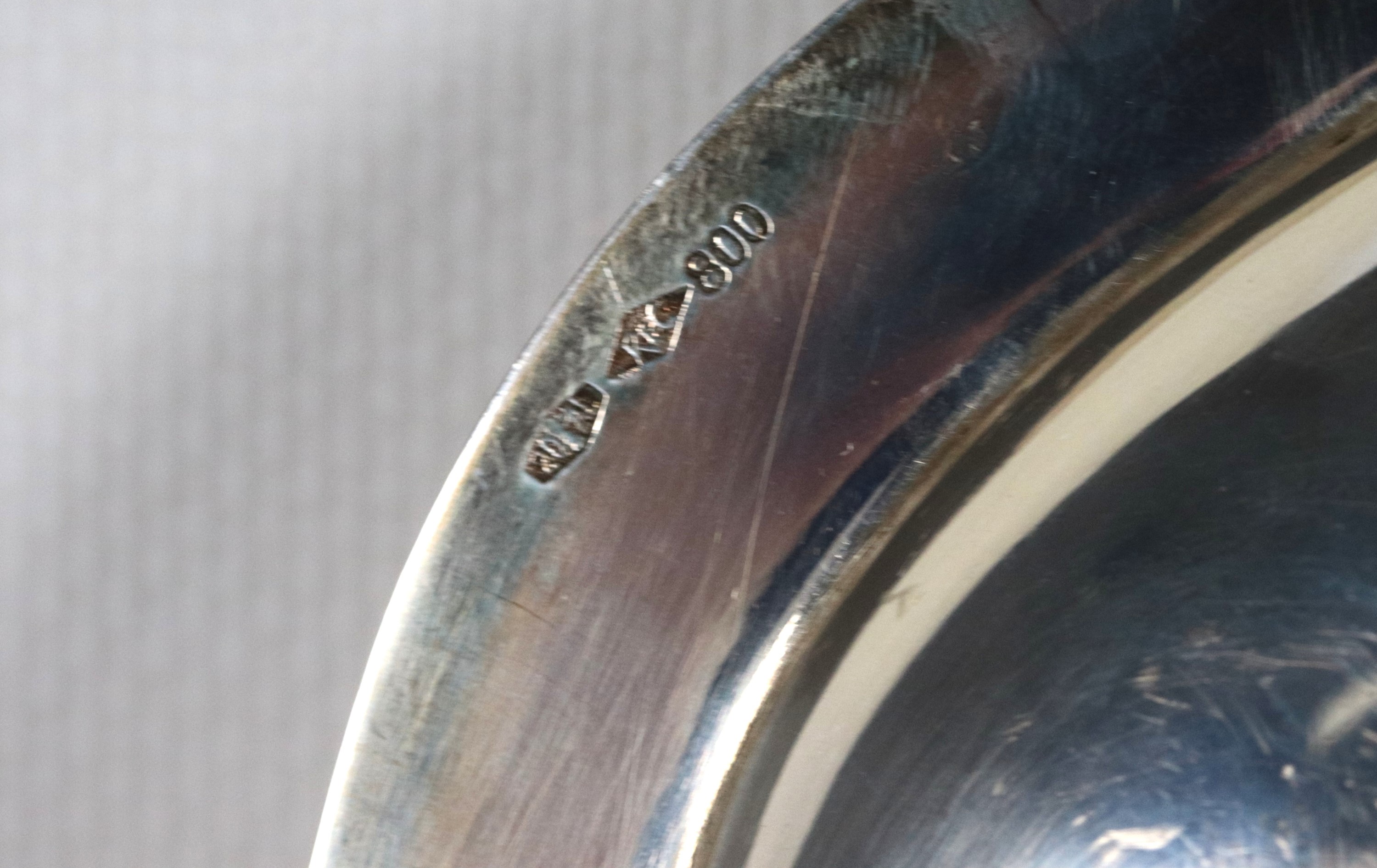 Piatto tondo in argento con bordo centinato, sbalzato e cesellato, gr. 720