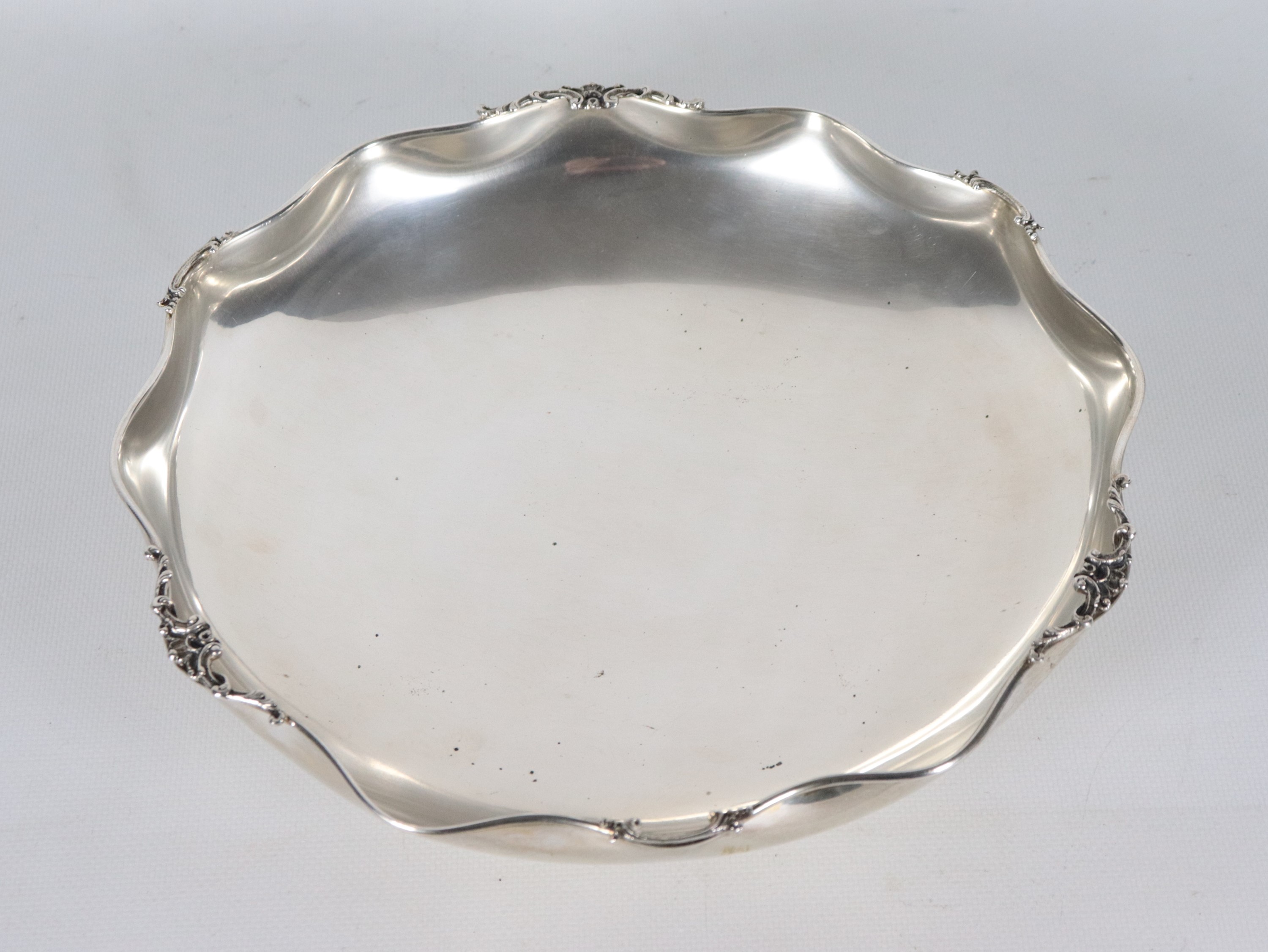 Fruttiera tonda in argento con bordo sagomato e sbalzato a volute, gr. 540