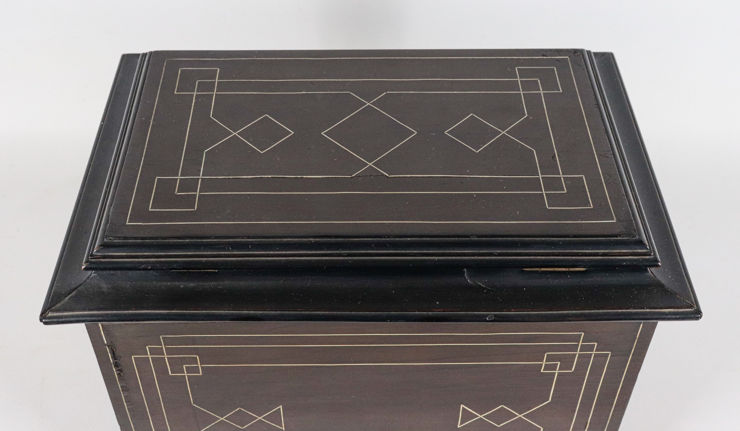 Antico scrigno in legno ebanizzato e intarsiato, con tre tiretti e uno sportellino