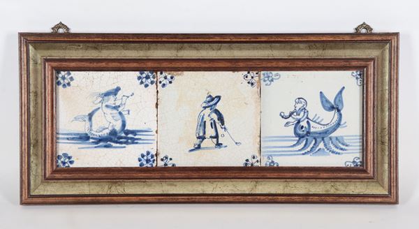 Lotto di tre antiche mattonelle in maiolica, con decorazioni in blu di personaggi, riunite in un'unica cornice