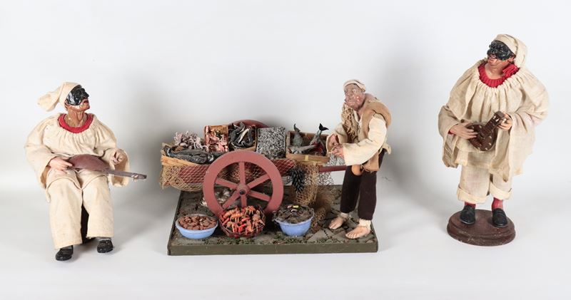 "Due pulcinella suonatori e venditore di pesce con carretto", lotto di tre pupazzi del presepe na...