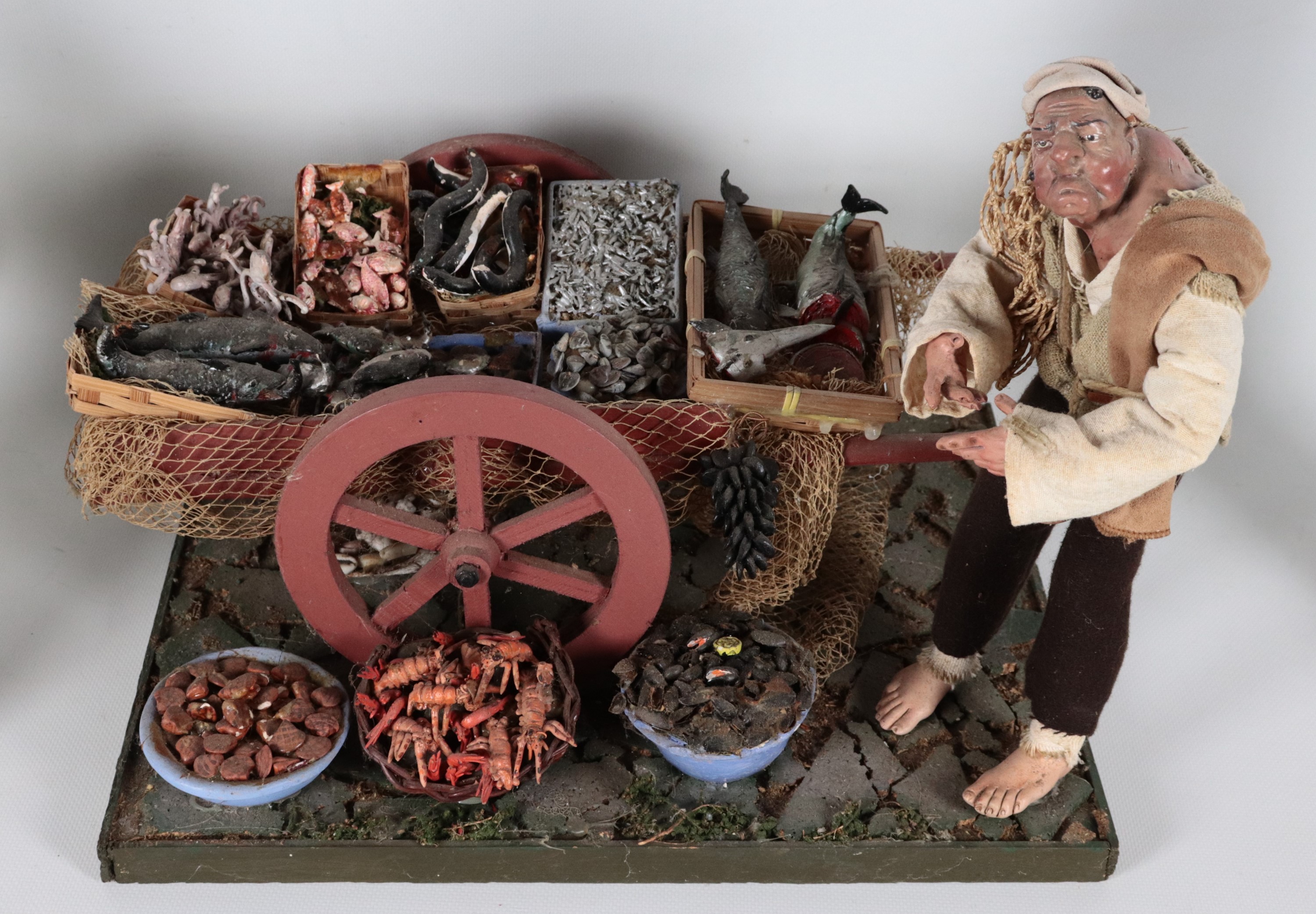 "Due pulcinella suonatori e venditore di pesce con carretto", lotto di tre pupazzi del presepe na...