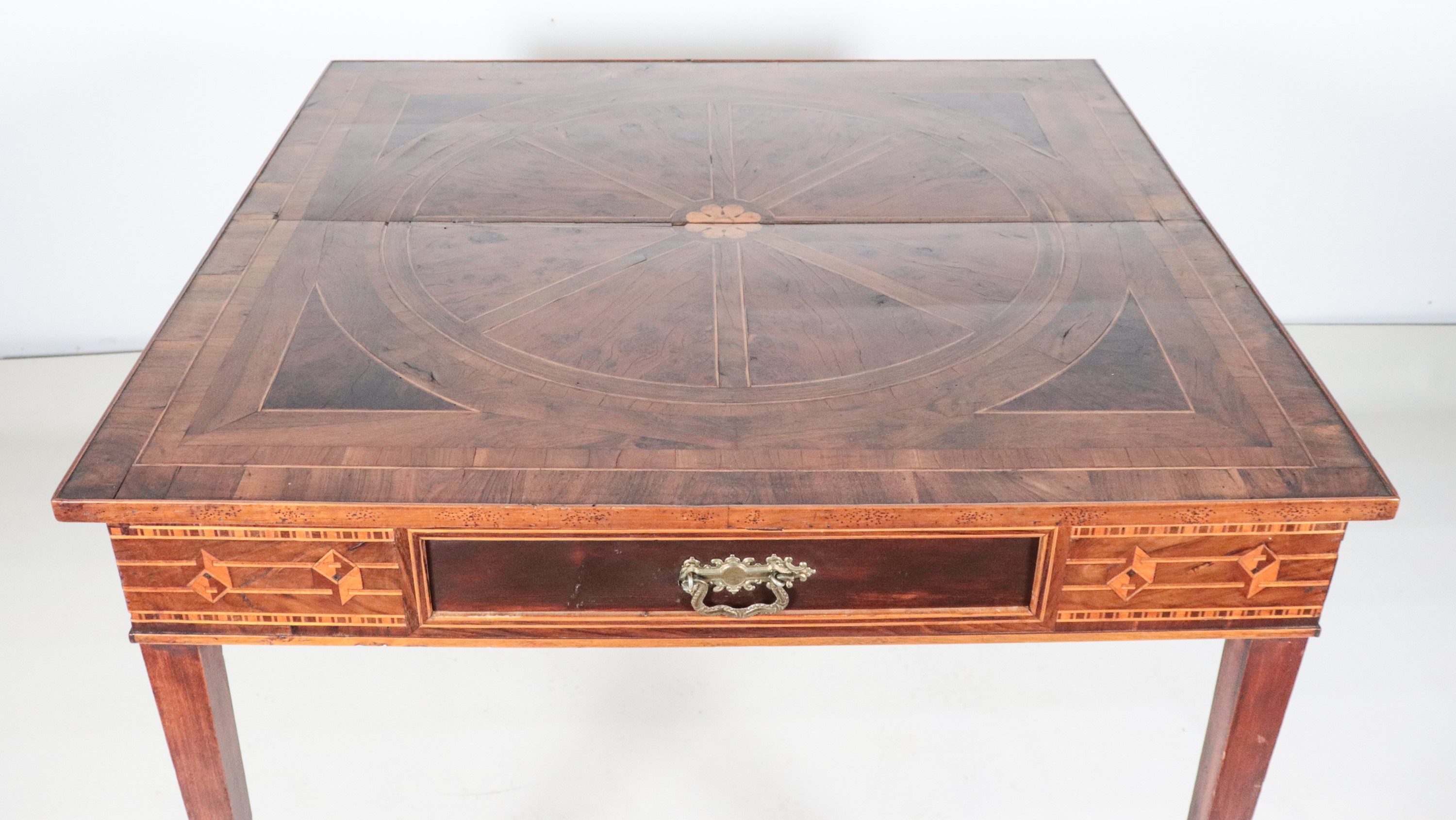 Antico tavolo lombardo da centro in noce, con intarsi a motivi geometrici in bois de rose e bosso