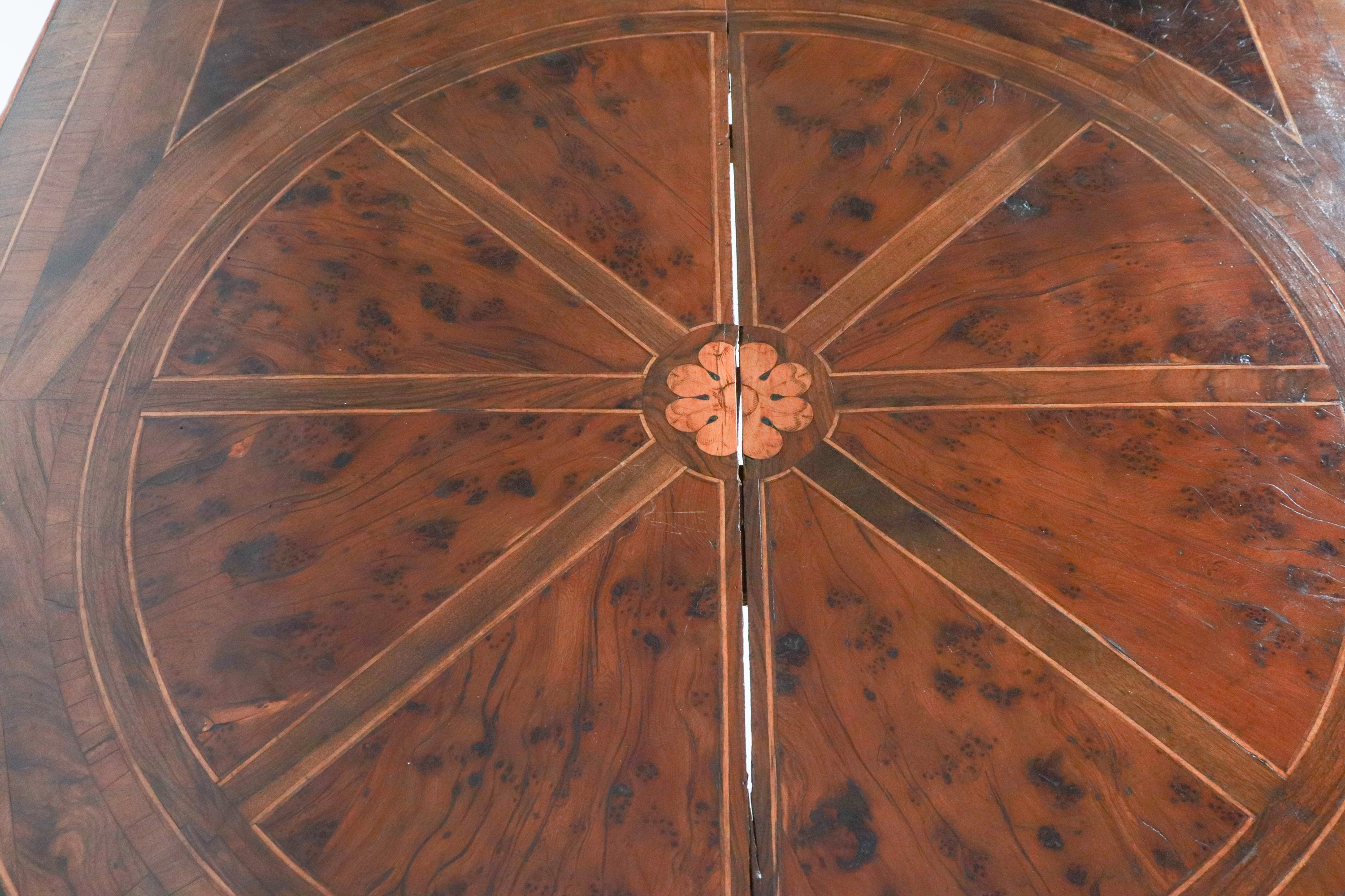 Antico tavolo lombardo da centro in noce, con intarsi a motivi geometrici in bois de rose e bosso