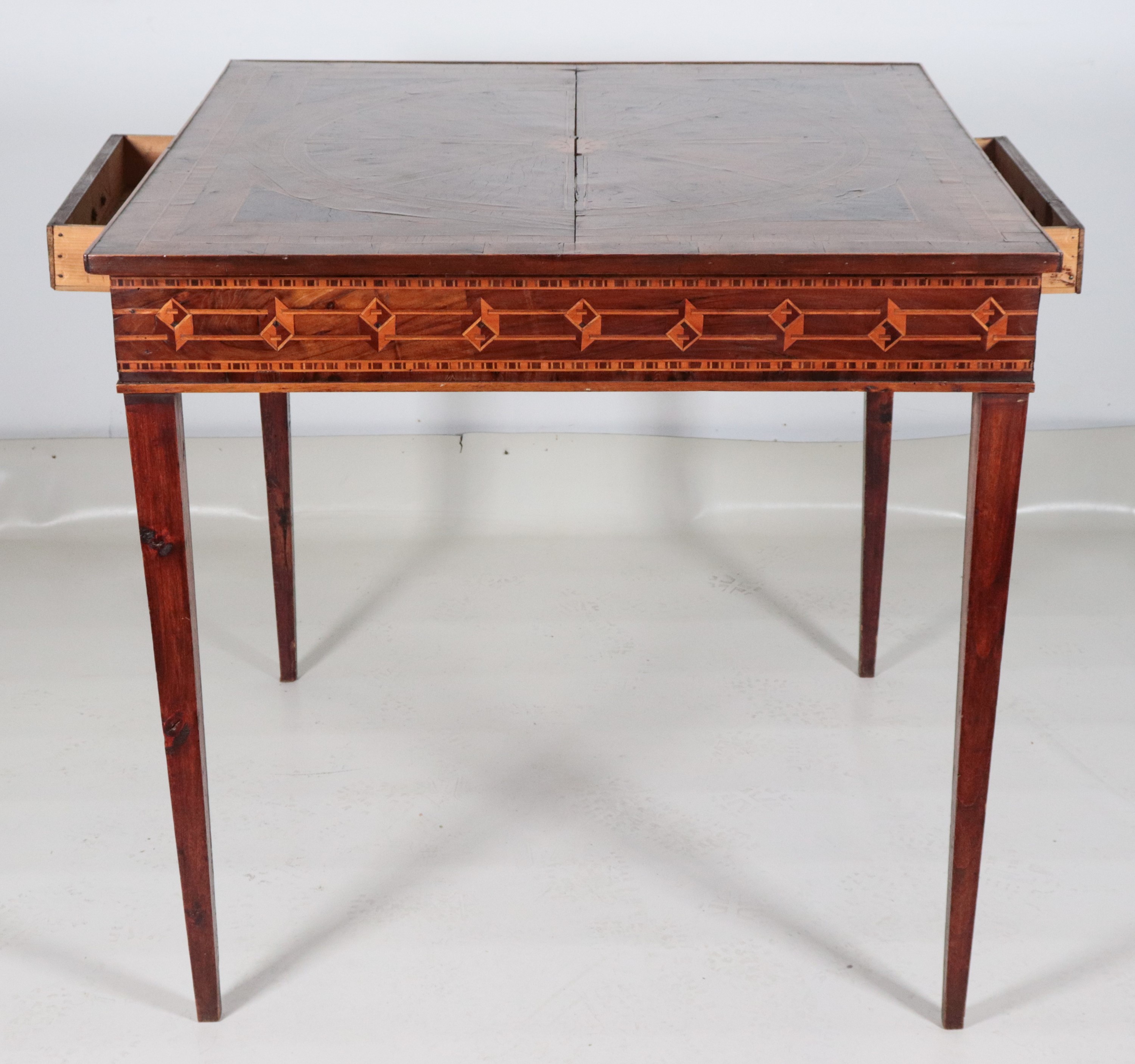 Antico tavolo lombardo da centro in noce, con intarsi a motivi geometrici in bois de rose e bosso