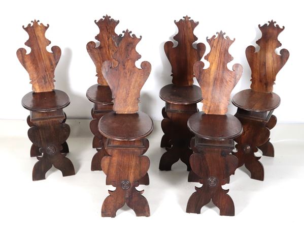 Lotto di sei antichi sgabelli in noce di linea rinascimentale, con schienali a scudo intagliati