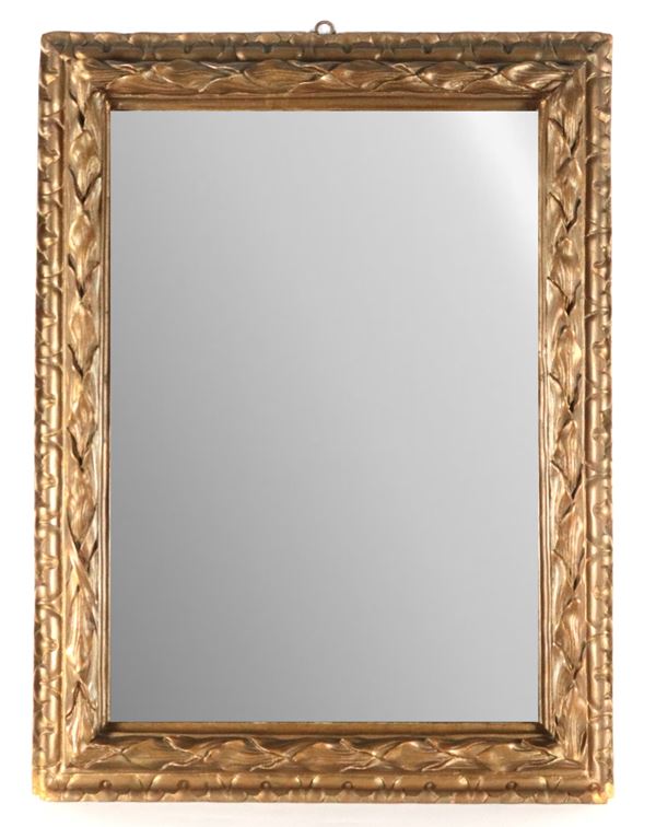 Antica cornice in legno dorato e intagliato a motivi di foglie d'acanto intrecciate