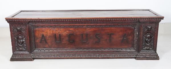 Antica cassapanca marchigiana in noce, con intagli a baccellature e mascheroni di figure muliebri ai lati