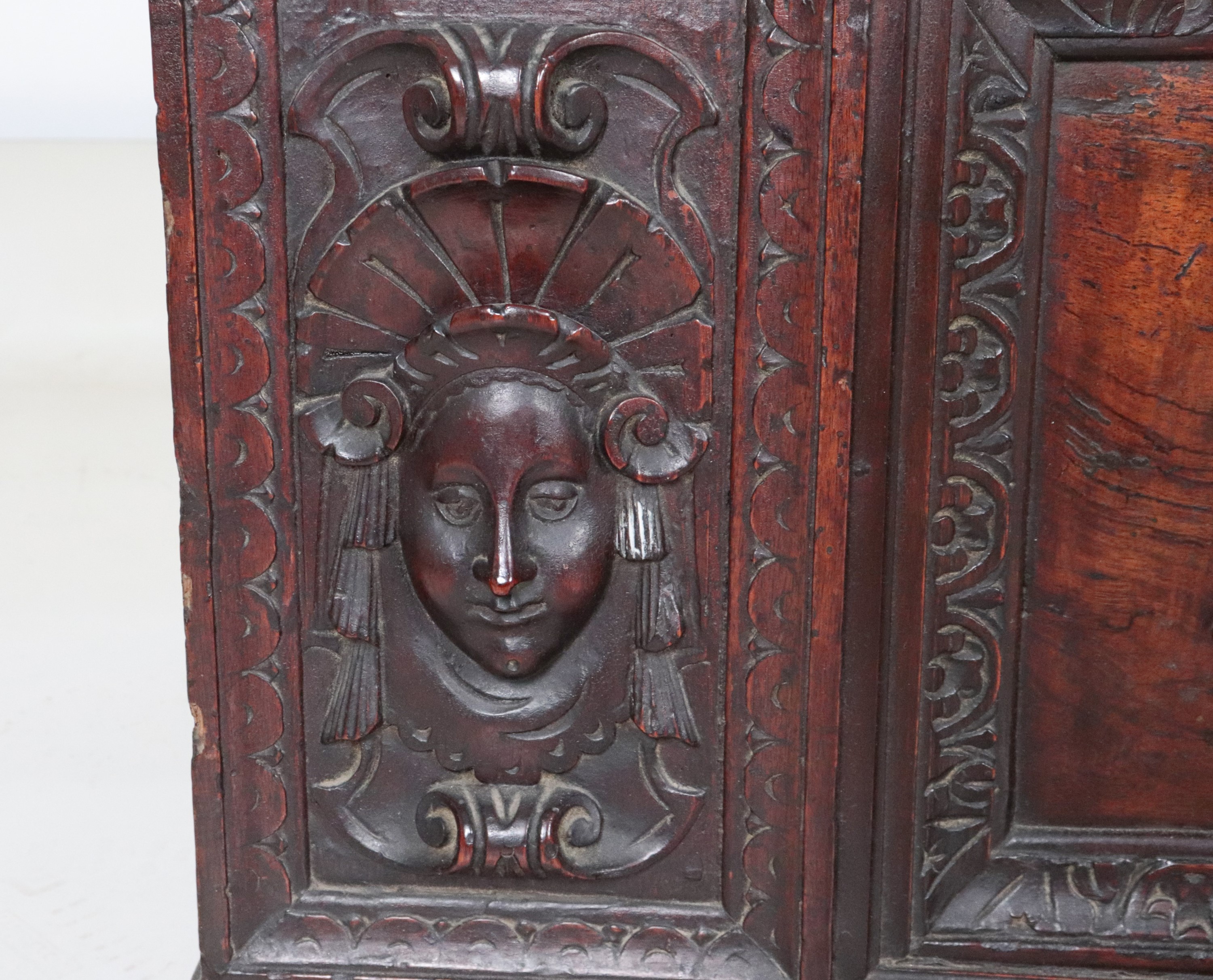 Antica cassapanca marchigiana in noce, con intagli a baccellature e mascheroni di figure muliebri...