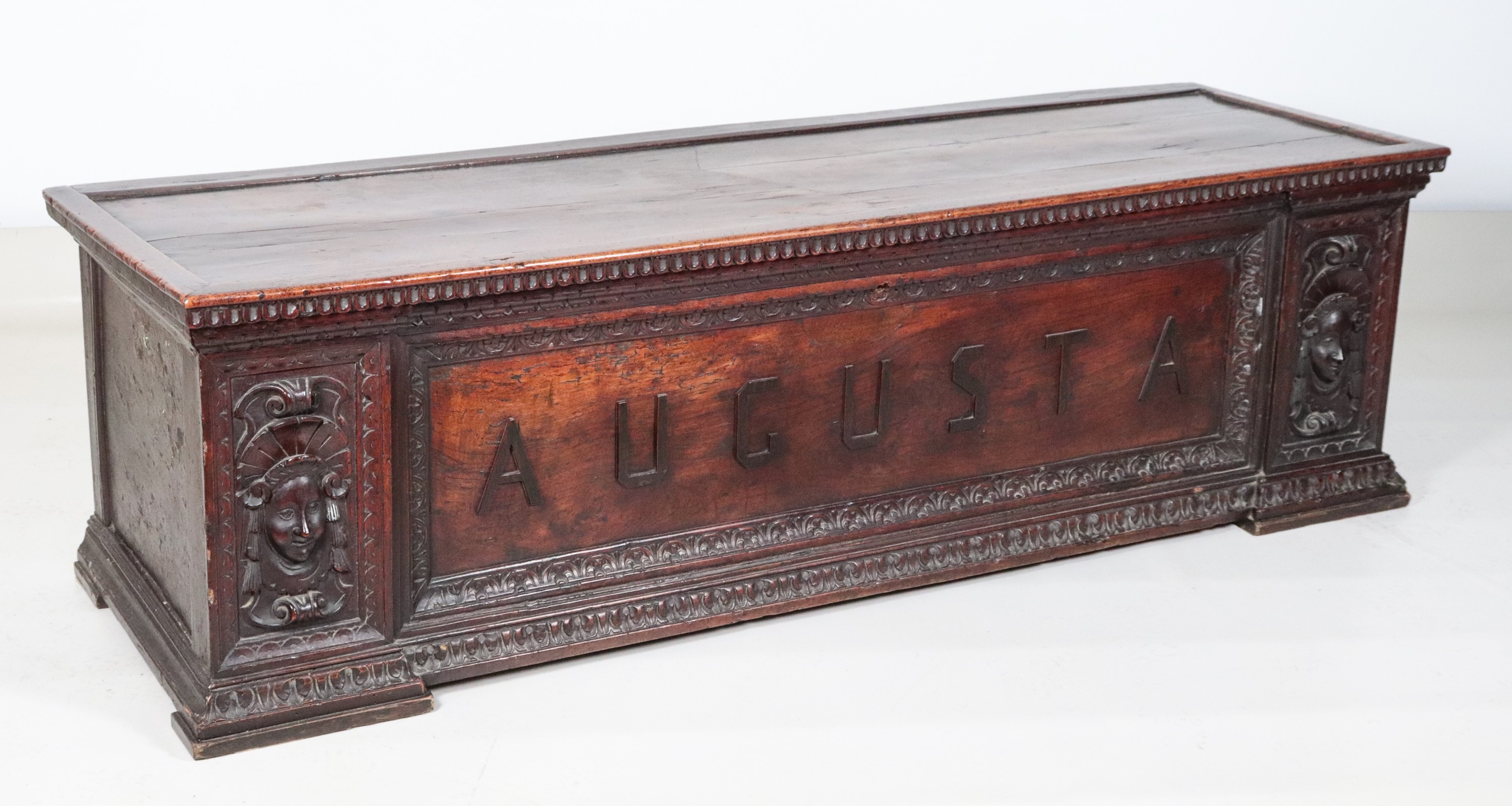 Antica cassapanca marchigiana in noce, con intagli a baccellature e mascheroni di figure muliebri...