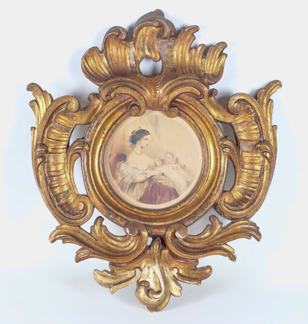 Antica cornice in legno dorato e intagliato a motivi di volute, all'interno incisione colorata raff.te "Mamma con figlioletto"