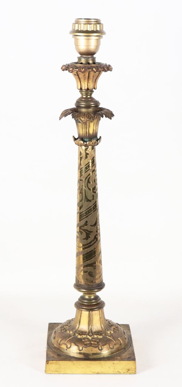 Candeliere in bronzo dorato a forma di colonna, sorretta da base quadrata