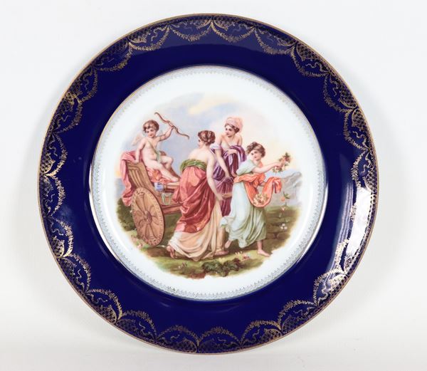 Antico piatto in porcellana Royal Vienna con al centro scena mitologica dipinta, bordo in blu cobalto decorato con festoni dorati
