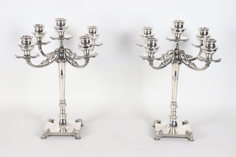 Coppia di candelabri in argento cesellato e sbalzato a motivi Impero, cinque fiamme ciascuno, gr....