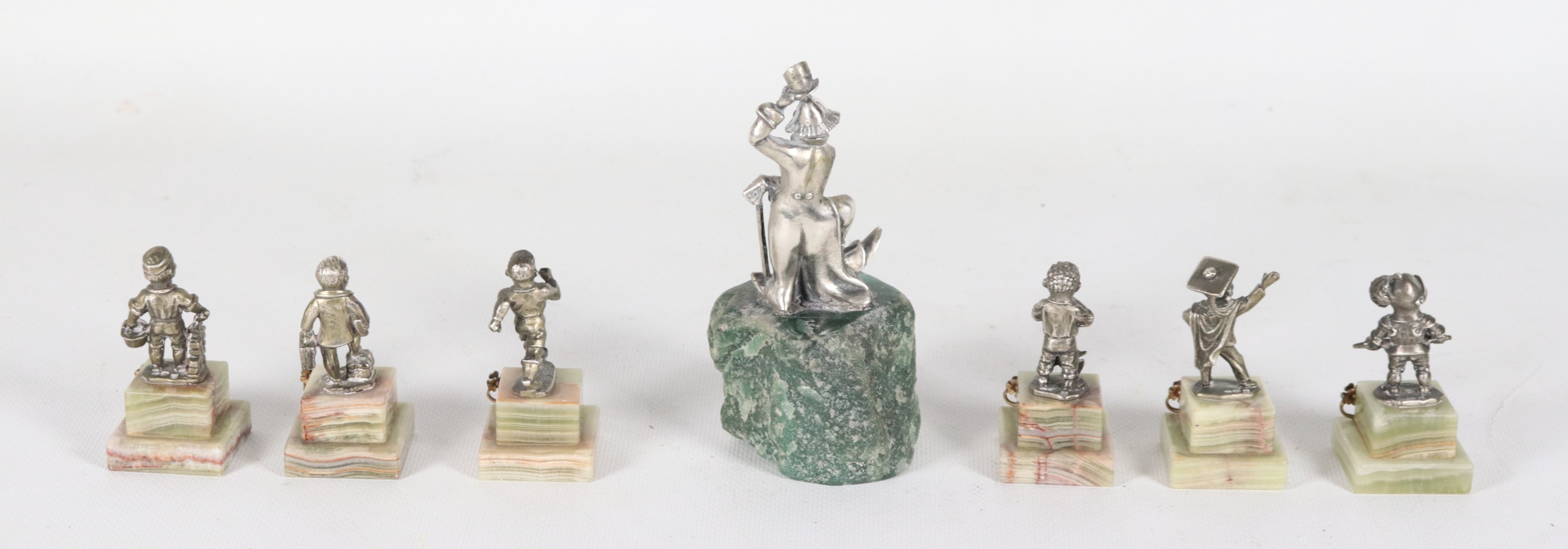 Lotto di sette piccole statuine in argento con basi in marmo raff.ti "Pagliaccio" e "Caricature d...
