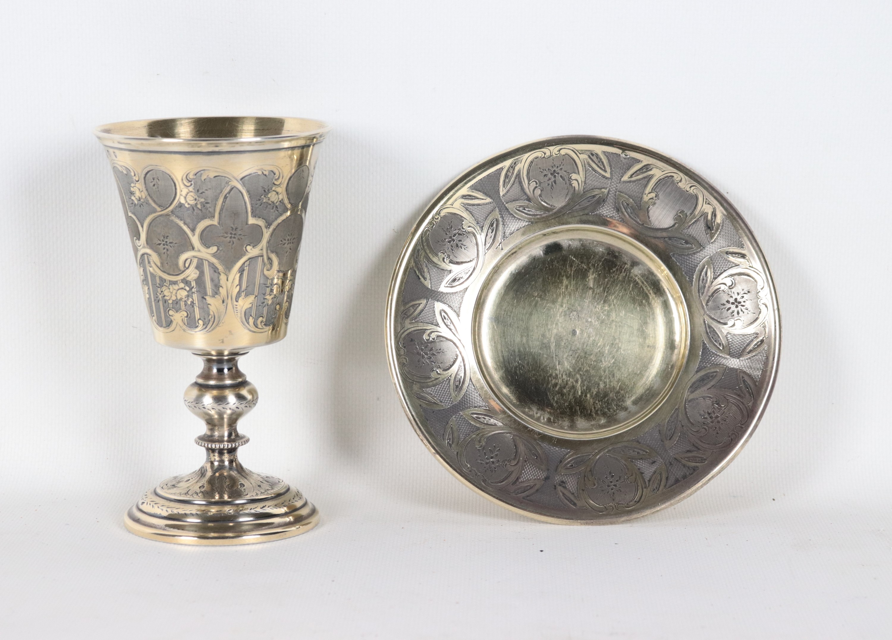 Bicchiere a calice con piattino in argento cesellato, gr. 200