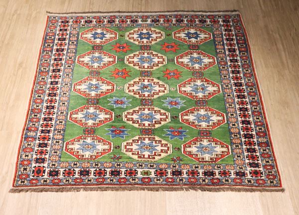 Tappeto persiano Yomut a disegni geometrici su fondo verde