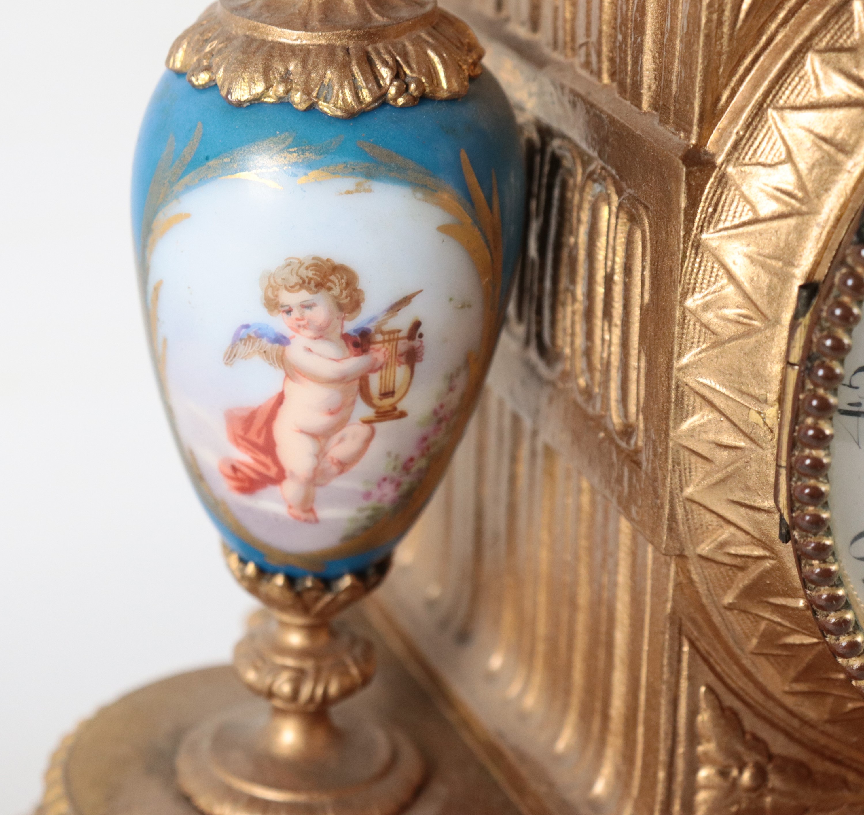 Antica pendola da tavolo francese in bronzo dorato e sbalzato a motivi Luigi XVI, con placche e v...