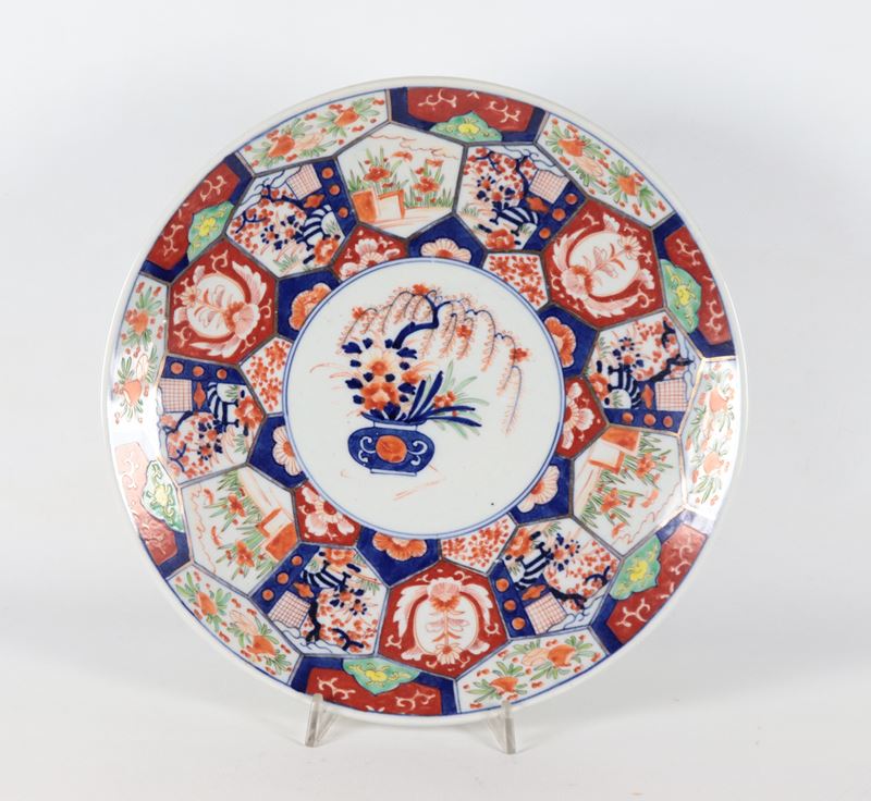 Antico piatto giapponese in porcellana Imari, con decorazioni in smalti rosso e blu a motivi di p...