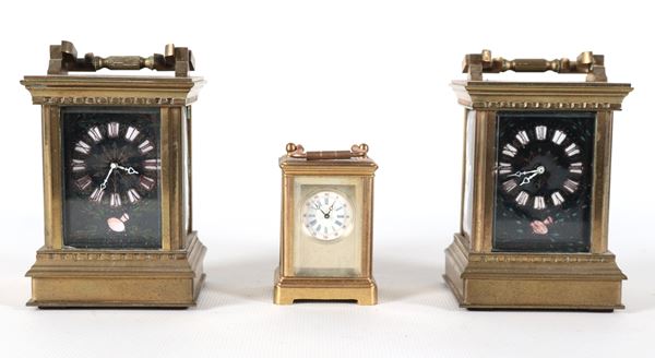 Lotto di tre cappuccine da viaggio in ottone dorato, due con quadrante decorato in nero e cifre romane, una più piccola con quadrante in smalto
