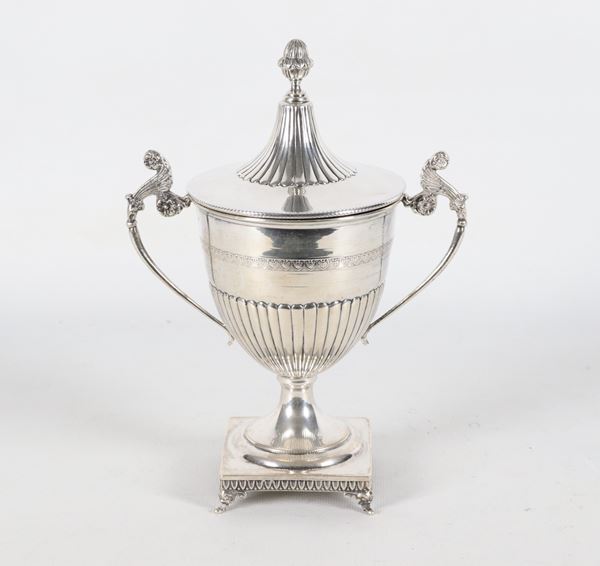 Zuccheriera in argento cesellata e sbalzata a motivi Impero, sorretta da quattro piedini ricurvi, gr. 420