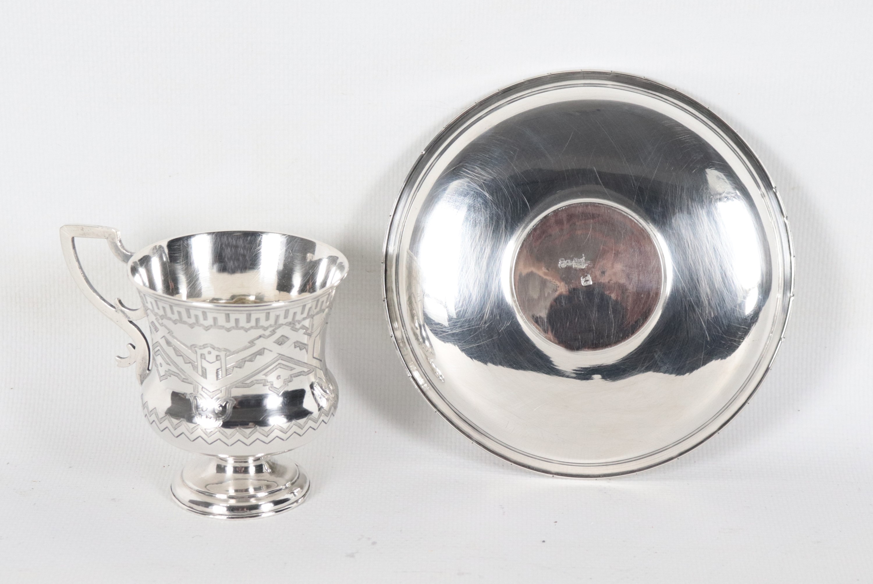Antica tazzina con piattino, in argento cesellato e sbalzato a motivi di intrecci geometrici, gr....