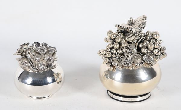Lotto di due scatole tonde rivestite in argento titolo 999, con coperchi a motivi di frutta e fiori