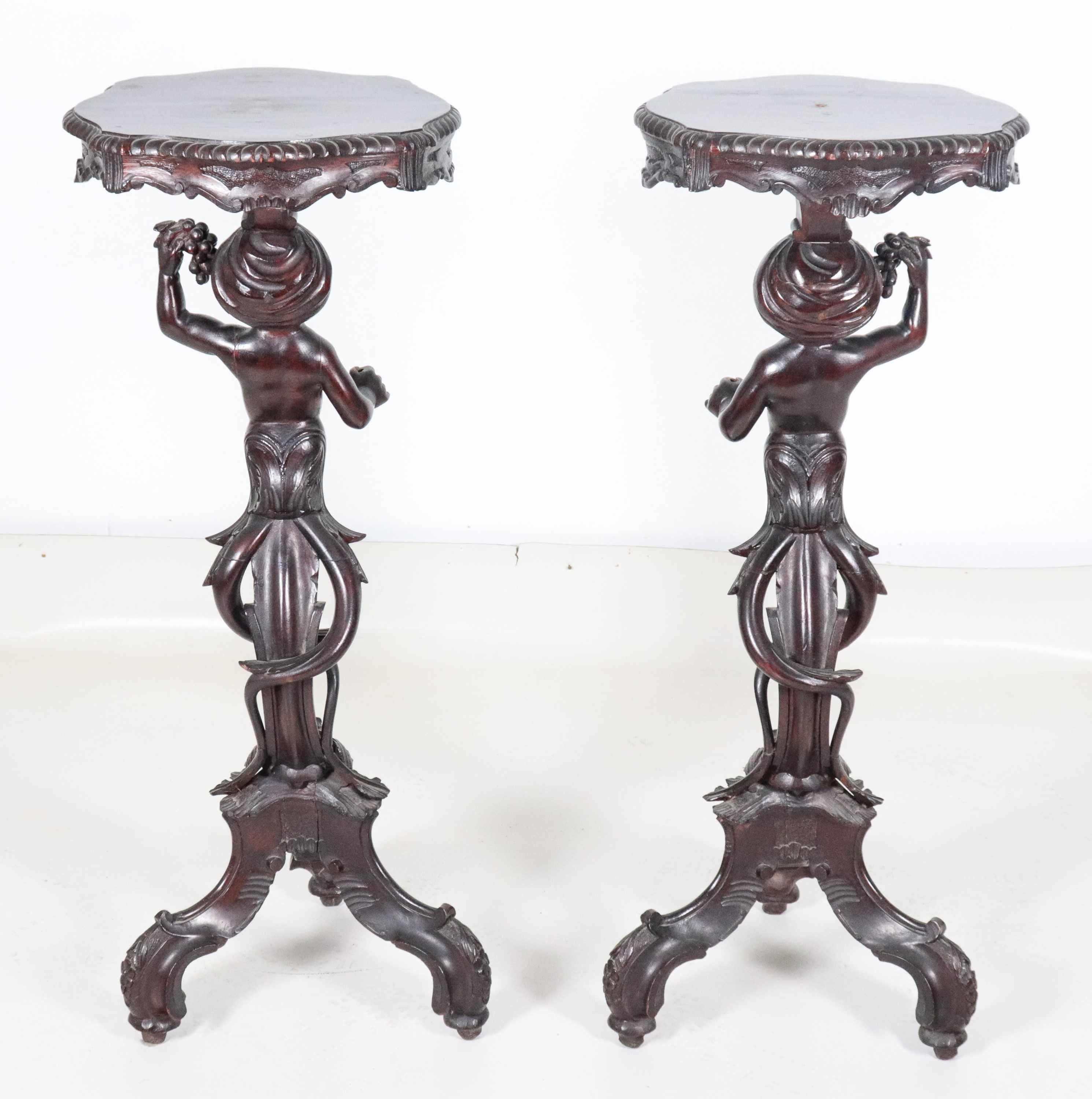 Coppia di antichi trespoli veneziani in noce, con sculture di "Moretti" e tre gambe centinate