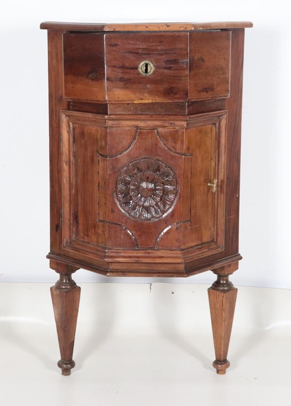 Antica piccola angoliera sagomata in noce, con rosone intagliato al centro