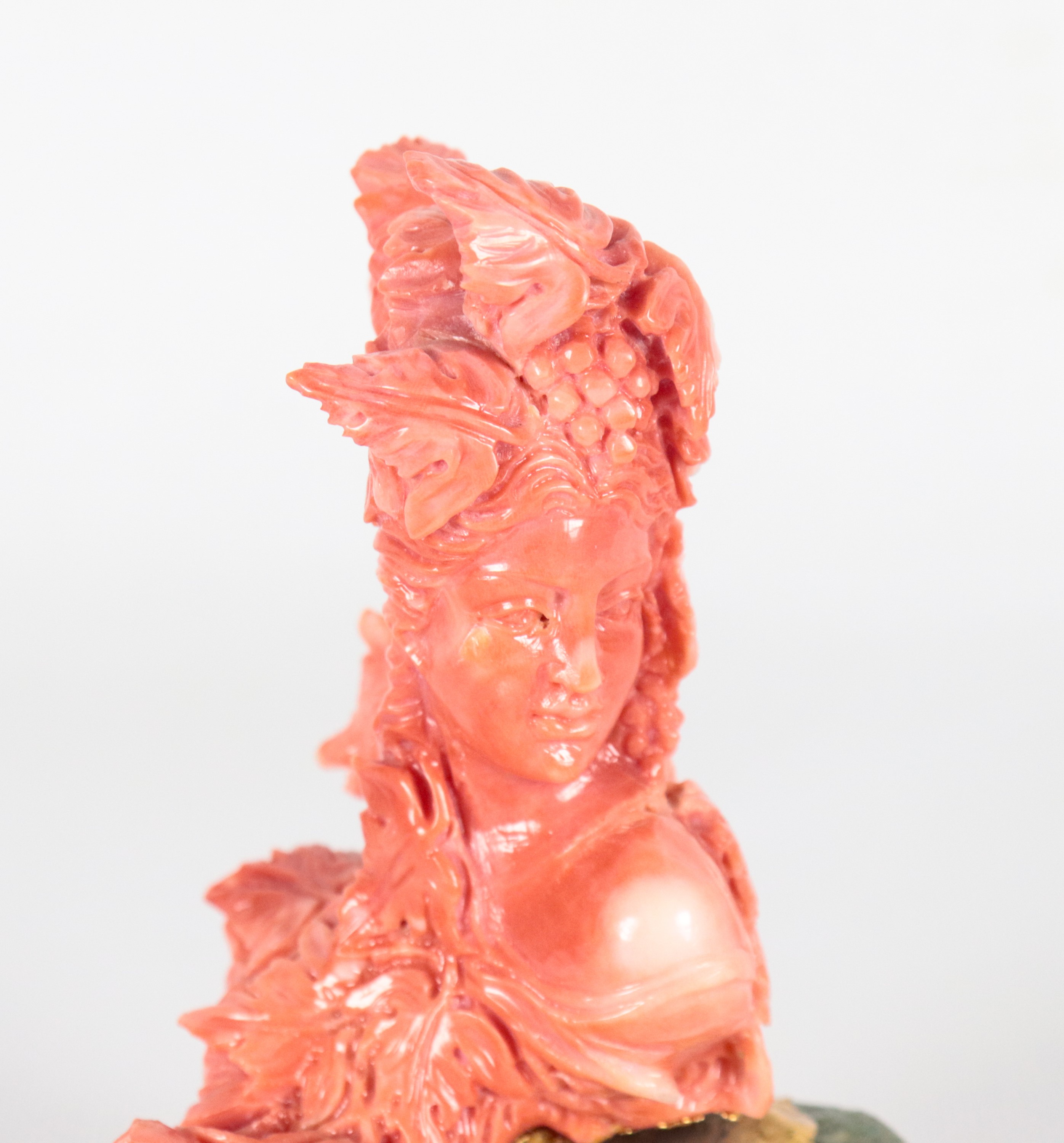 Piccola scultura in corallo "Busto femminile con grappoli d'uva" con base in pietra dura