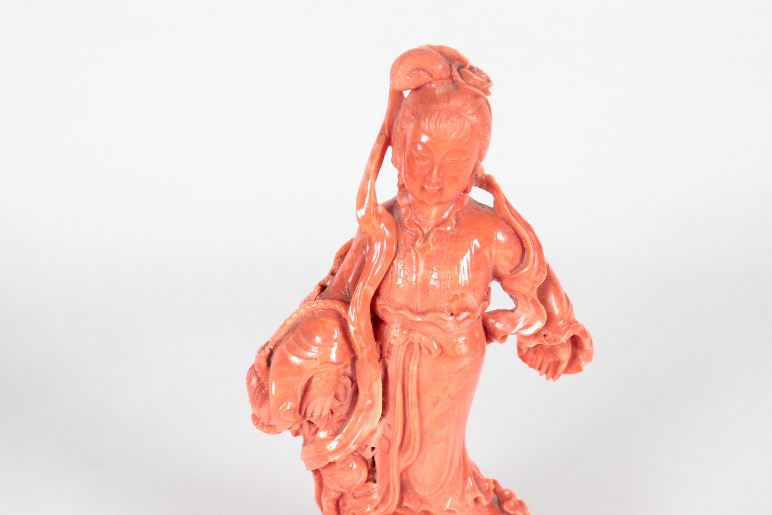 Piccola scultura in corallo "Figura femminile con cesto" con basetta in teak