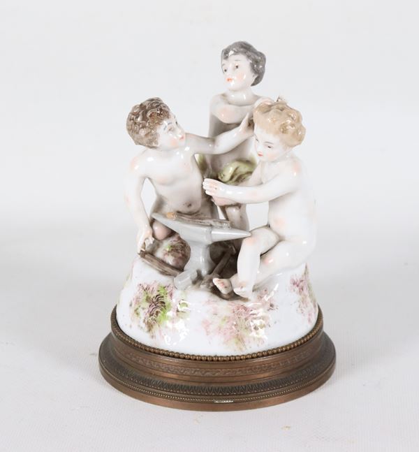 "Allegoria di putti", piccolo gruppo in porcellana policroma, sorretto da base in bronzo cesellato e sbalzato