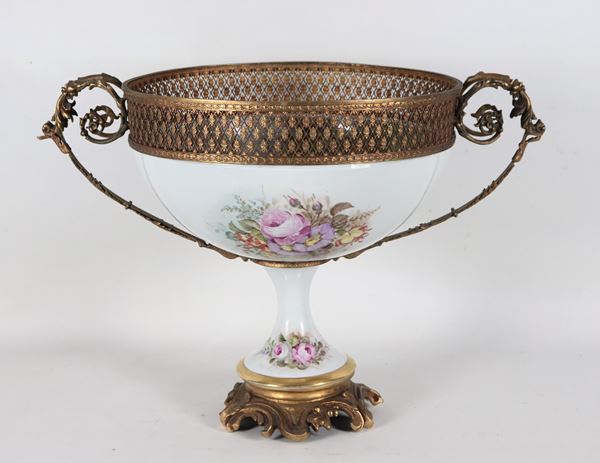 Centrotavola francese a coppa in porcellana, metallo dorato e bronzo, con decorazioni policrome dipinte a mazzetti di rose e giovane nobildonna sull'altalena. Firmata