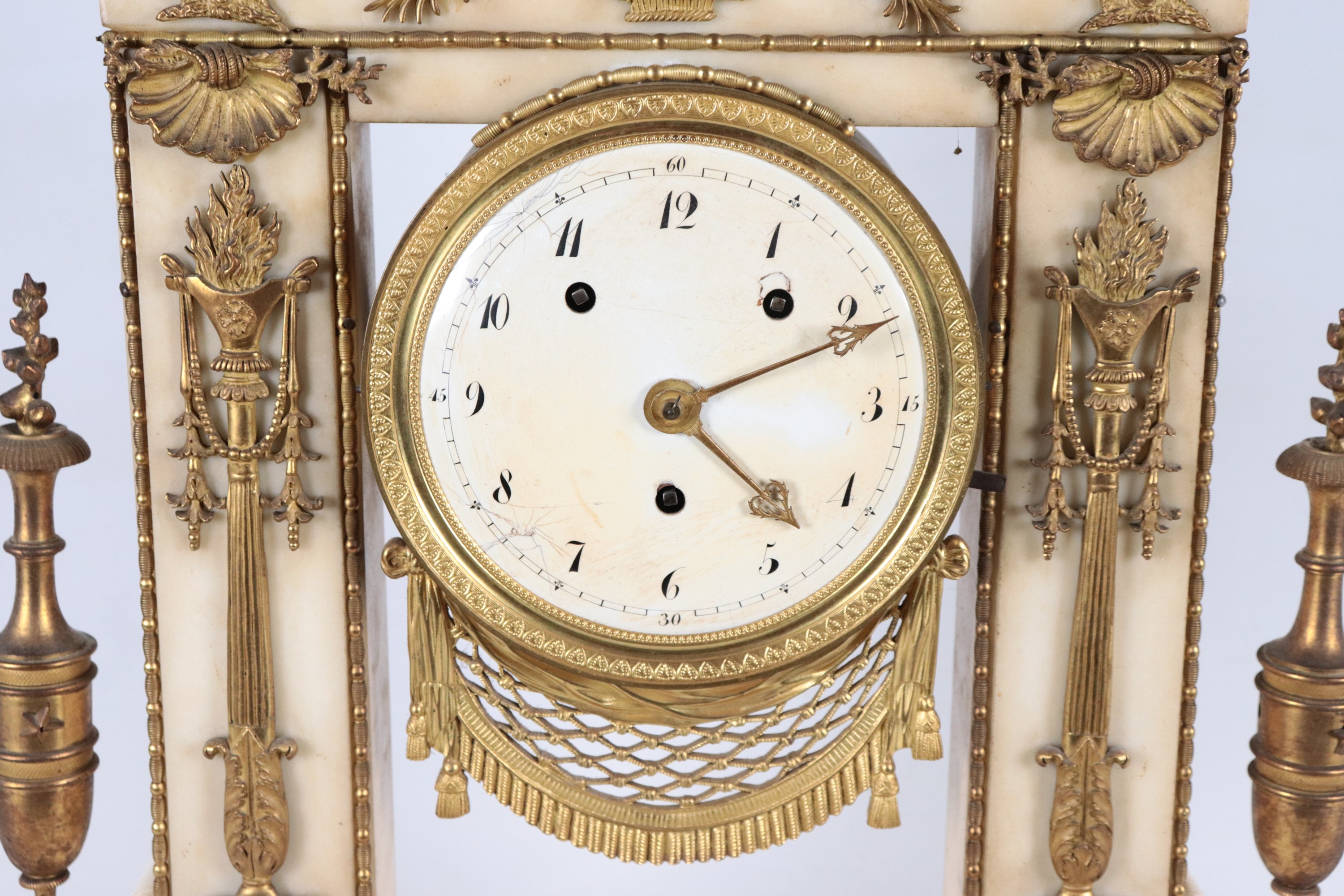 Antica pendola da tavolo francese Epoca Impero, in marmo bianco con fregi e guarnizioni in bronzo...