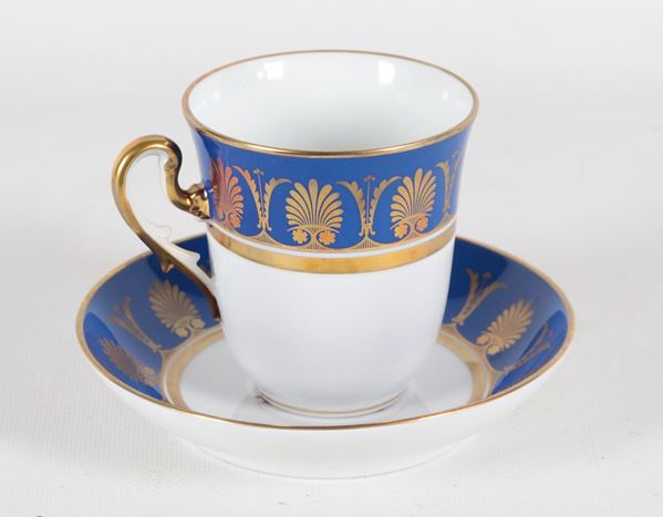 Tazza con piatto in porcellana Richard Ginori, con decorazioni Impero in oro zecchino su fondo blu e bianco, al centro del piattino decoro con scena campestre
