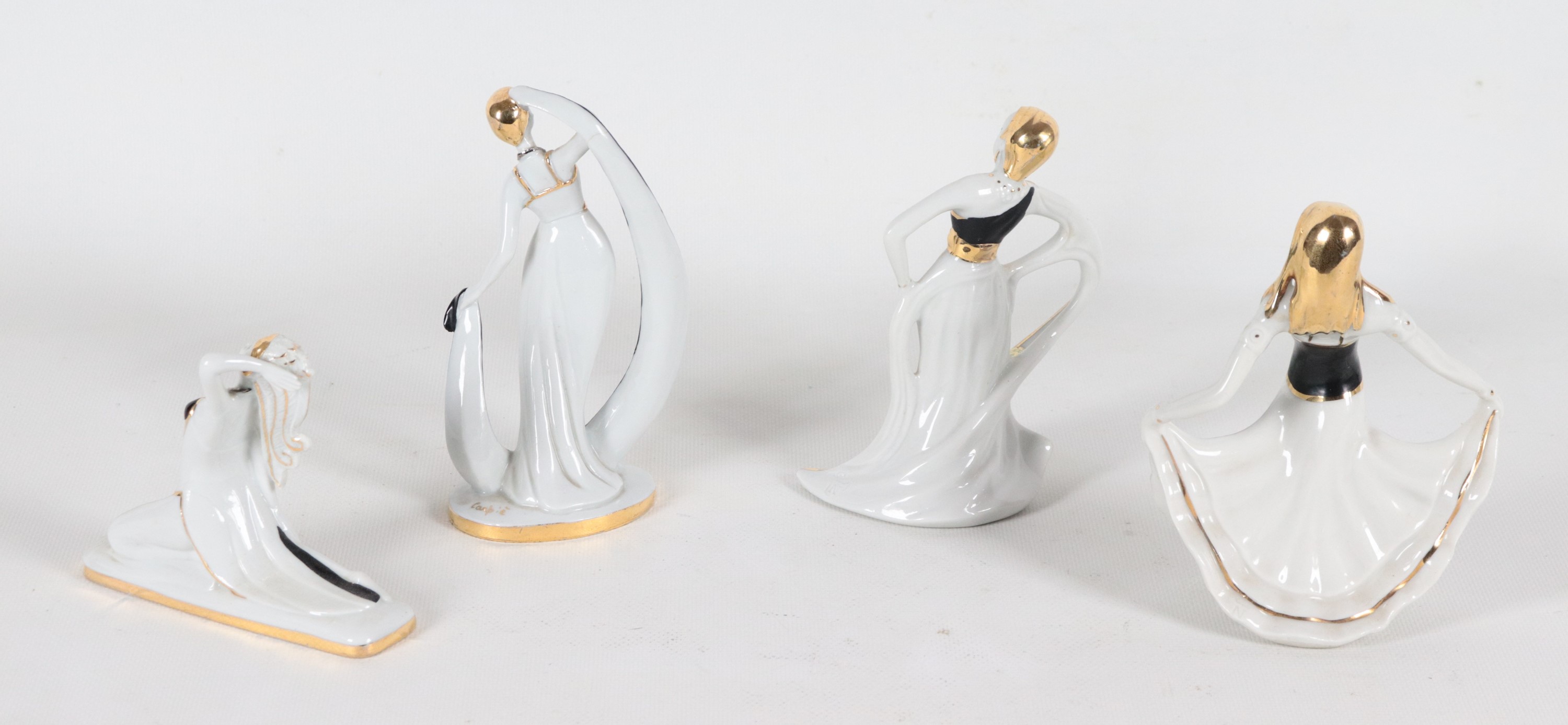 'Ballerine', lotto di quattro statuine di gusto Liberty in porcellana smaltata bianca e nera. Due...