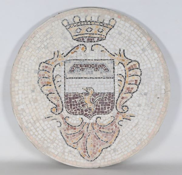 Round marble top worked with a mosaic pattern and a "family crest" in the center 
