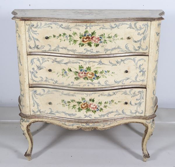 Piccolo comò marchigiano di linea Luigi XV, in legno laccato avorio interamente decorato e dipinto a intrecci floreali e mazzetti di rose