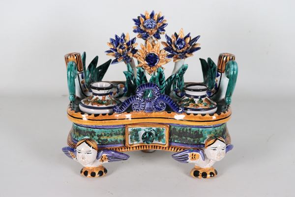 Polychrome Sciacca majolica inkwell with floral motifs and winged figures