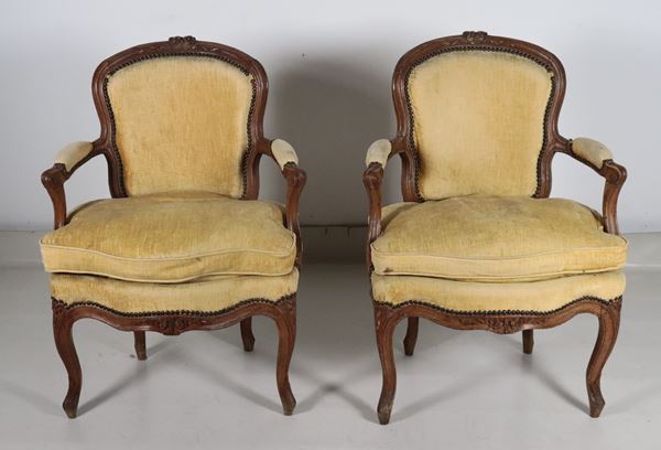 Pair of antique French Louis XV style walnut armchairs, with carvings of flower bouquets.