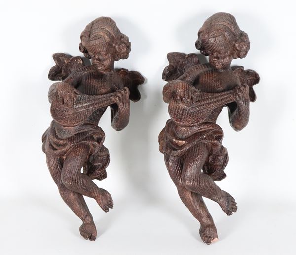 "Putti suonatori", coppia di piccole sculture in legno patinato
