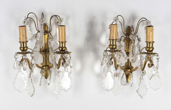 Pair of antique small gilded bronze wall lamps with crystal prisms, two lights each