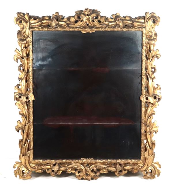Antica grande specchiera in legno dorato e intagliato a motivi Luigi XV di ricci, volute di foglie d'acanto intrecciate e riquadro con foglie d'alloro, specchio al mercurio