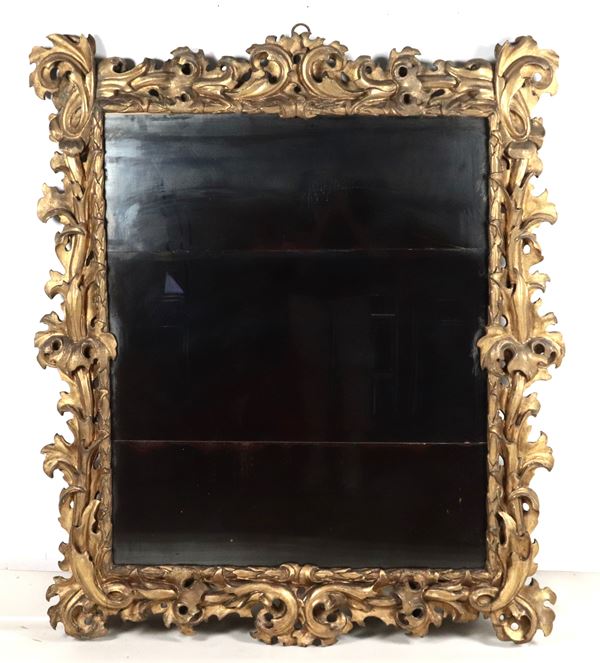 Antica grande specchiera in legno dorato e intagliato a motivi Luigi XV di ricci, volute di foglie d'acanto intrecciate e riquadro con foglie d'alloro, specchio al mercurio
