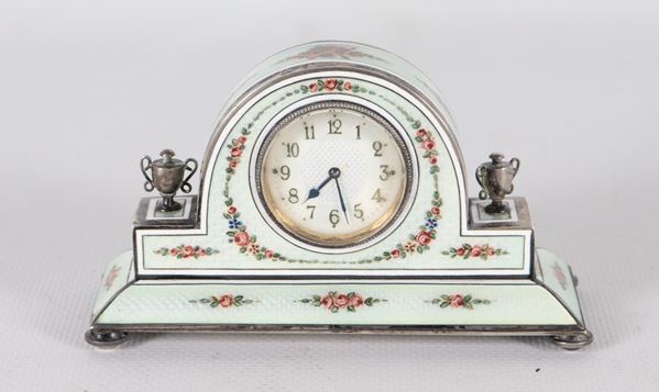 Antique small clock in enamel and silver, with floral garland decorations and two small amphorae on the sides, dial with Arabic numerals