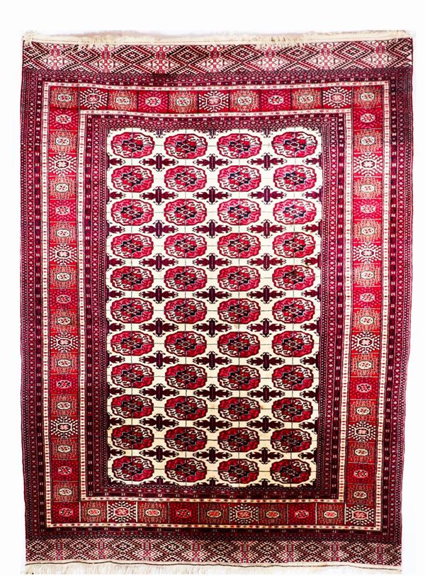 Persian Bukara carpet with geometric motifs on a red background