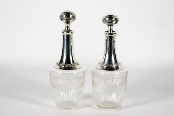 Pair of antique engraved crystal bottles with silver-coated neck and cap