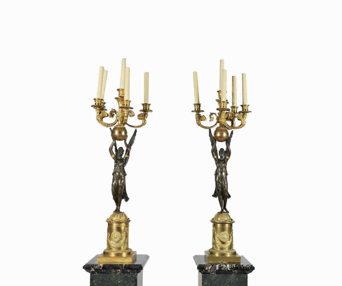 Coppia di grandi candelabri con sculture di "Vittorie alate" in bronzo patinato e dorato