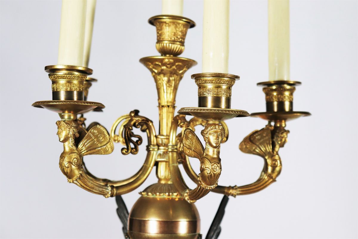Coppia di grandi candelabri con sculture di "Vittorie alate" in bronzo patinato e dorato