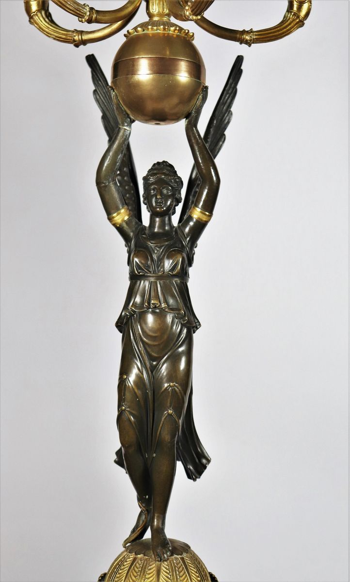 Coppia di grandi candelabri con sculture di "Vittorie alate" in bronzo patinato e dorato